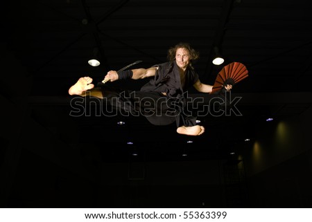 a samurai warrior flying high in an action kick