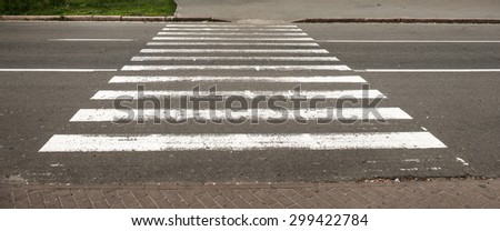 Pedestrian crossing white lines on the narrow asphalt road