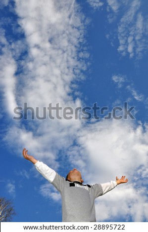 young boy raising hands up to the sky, space for copy