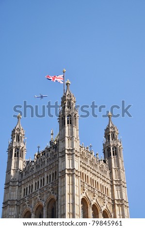 Plane is flying over British Parliament, sky is above