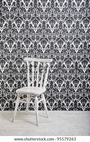 white wooden chair against vintage style wallpaper in studio