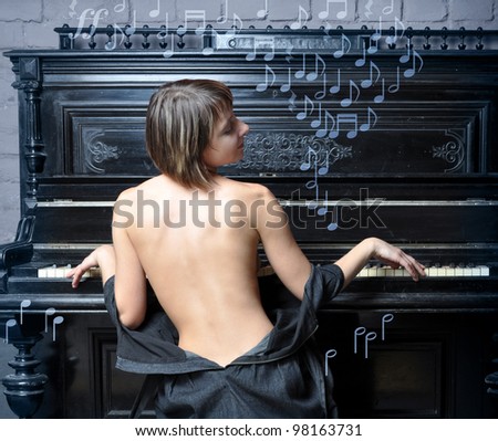 Sensual semi-dressed woman performing romantic music on piano, music symbols