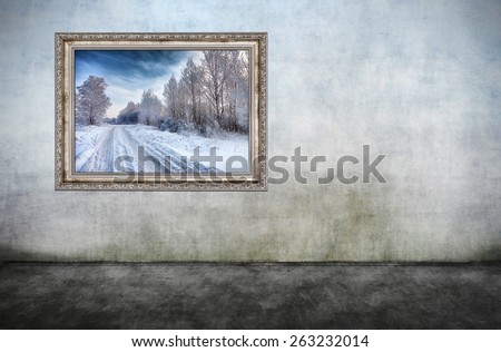 Old wooden frame with beautiful winter landscape on dirty wall. There is no copyright infringement, photo inside is my property.