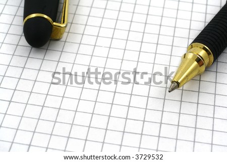 close-up of pen tip and blank squared paper