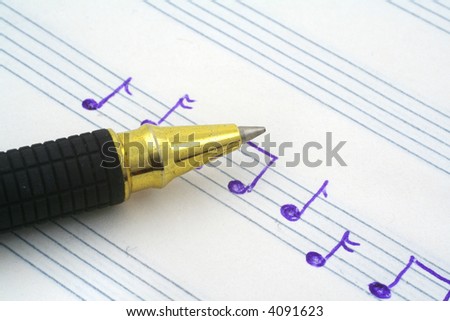 close-up of hand written music note and ballpoint pen tip