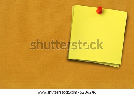 close-up of two yellow notes thumbtacked to brown paper