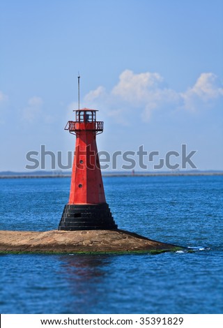 red lighthouse at the end of stone dike