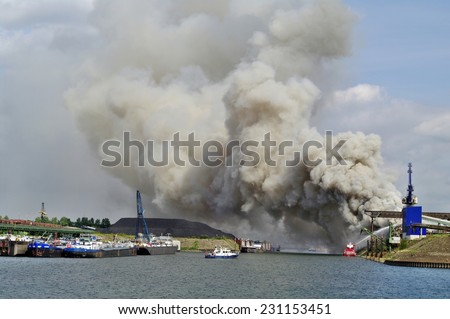 DUISBURG, GERMANY - 11 Septembert 2010 Fire with smoke on a scrap island in the  Logport inland port of Duisport.