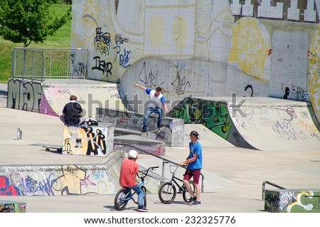 DUISBURG, GERMANY - 07 July 2013 The river bank Rhine. Skateboarders with friends in skate-park jumping in the halfpipe and on the other ramp