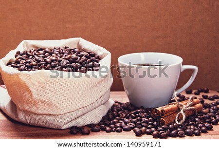 Coffee cup with sack of roasted beans