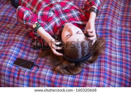 Pretty teenager hearing music on headphones