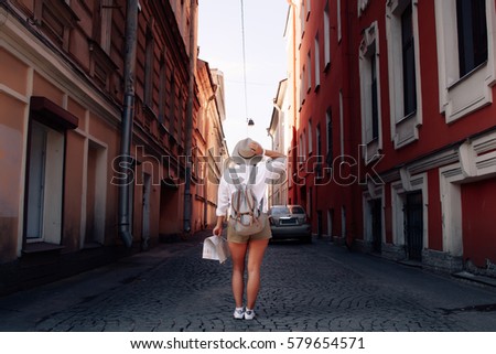 Travel guide. Young female traveler with backpack and with map on the street. Travel concept