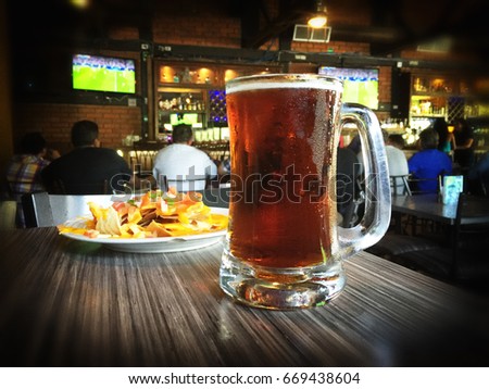 Nachos and beer on a table of a sports bar