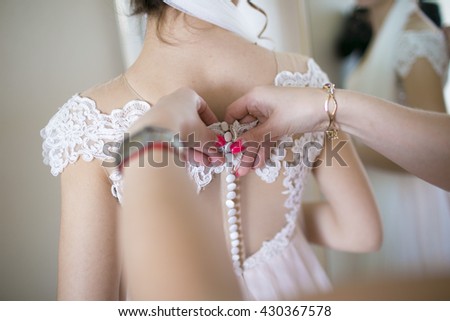 friend helps the bride to dress