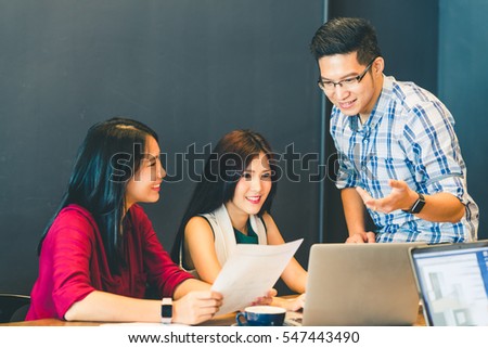Group of young Asian business colleagues or college students in team casual discussion, startup project business meeting or happy teamwork brainstorm concept, with copy space, depth of field effect