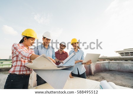 Multiethnic diverse group of engineers or business partners at construction site, working together on building\'s blueprint, architect industry or teamwork concept.