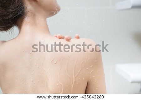 Beautiful girl washing her body shower gel