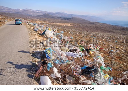 CRIKVENICA, CROATIA - MARCH 8, 2015: Discarded plastic shopping bags blown by wind  from an unguarded garbage disposal facility, polluting meadows on a hill slope in Croatia.