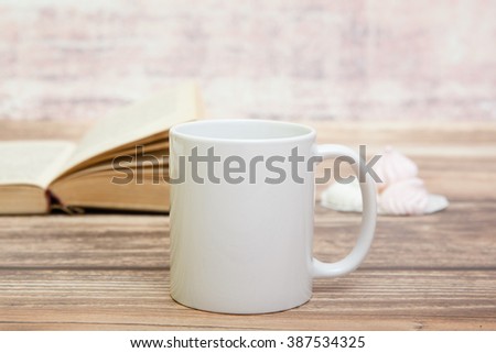 White mug with book behind it