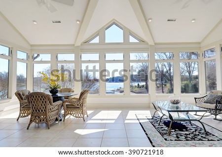 Sun Room with Large Windows Overlooking Lake