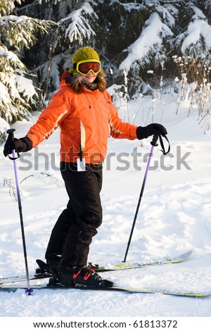 Young woman on ski in orange ski jacket