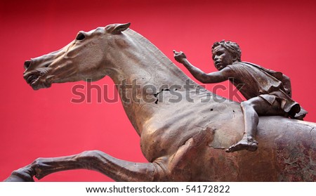 Ancient bronze Greek sculpture on red background