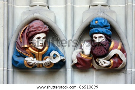 Polychrome sculpture on the facade of a church, two human figures