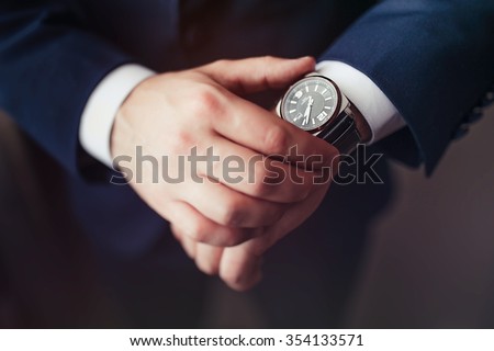 businessman looking watch on his wrist