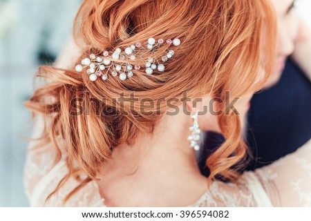 Closeup of wedding hairstyle with pearls of redhead bride