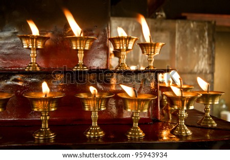 Candles burning in dark indoor Buddhism temple