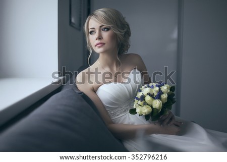 Beautiful bride in white wedding dress with bridal bouquet, with yellow and blue flowers