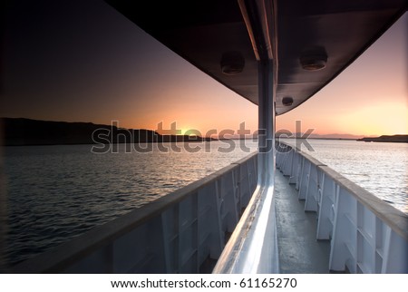 Sunset over the sea reflected in the windows of a boat