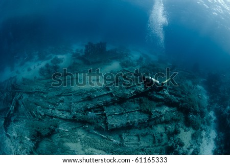Female scuba diver over Underwater wreckage from the Yolanda, which ran aground during a storm. Yolanda reef, Ras Mohammed national Park Red Sea, Egypt.
