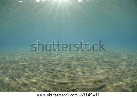 Sunrays and reflections on a sanday ocean floor
