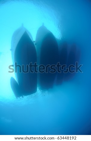 Underwater view of dive boats moored up together.