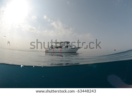 Dive boat on a calm ocean with mountain desert background