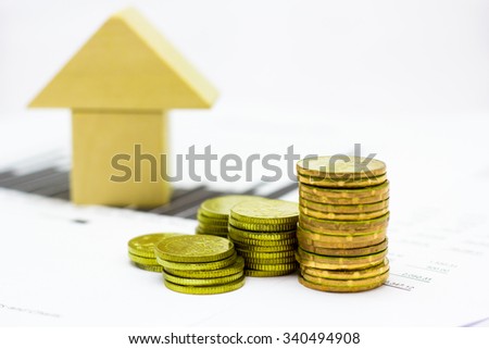 Wooden house block and Financial statement with coins. (finance, property and house loan concept)