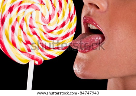 woman sucking cute sweet candy closeup lips tongue isolated on black background