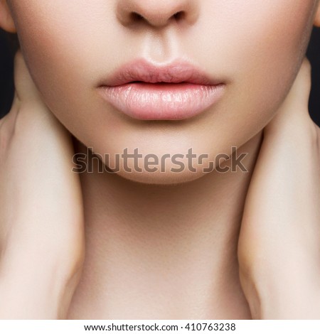 Sexual full lips. Natural gloss of lips and woman's skin. The mouth is closed. Increase in lips, cosmetology. Pink lips and long neck.