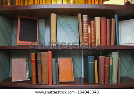 Old grunge books in leather binding on library shelf