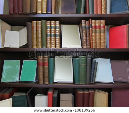Old books in leather binding on library shelf