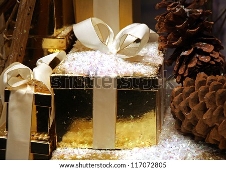 Christmas present packed in gold box with beige ribbon