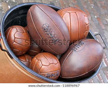 Bunch of leather sport balls in metal container