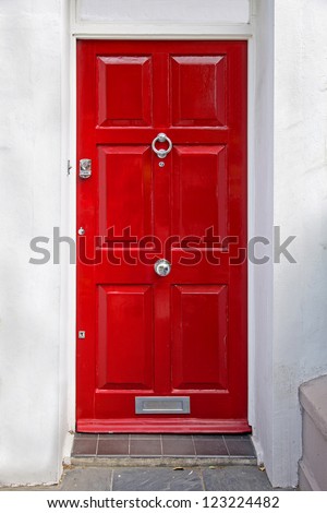Red entrance door in front of residential house