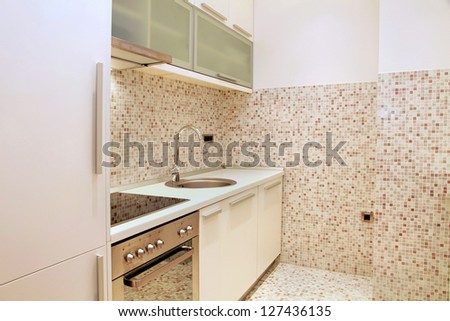 Modern kitchen interiors with beige mosaic tiles