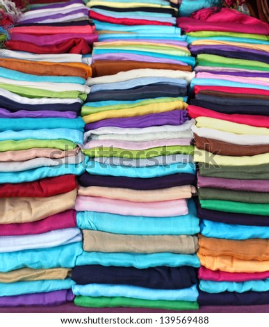 Colorful fashion scarves folded on market stall