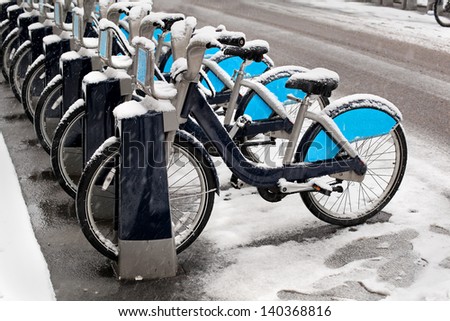 Bicycles parked on street sidewalk covered with snow