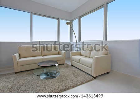 Modern living room interior with light furniture and large windows