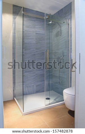 Modern shower with glass cabin inside bathroom interior