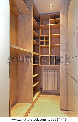 Empty walk in closet with wooden shelves